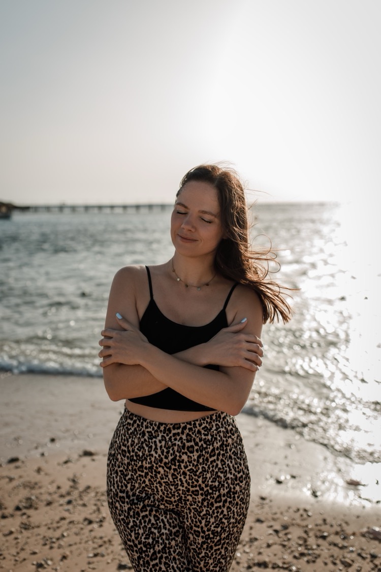 Sarah am Meer, die sich selbst umarmt